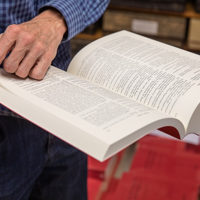 Robert Damme blättert durch den fünften und letzten Band des Westfälischen Wörterbuchs (vergrößerte Bildansicht wird geöffnet)