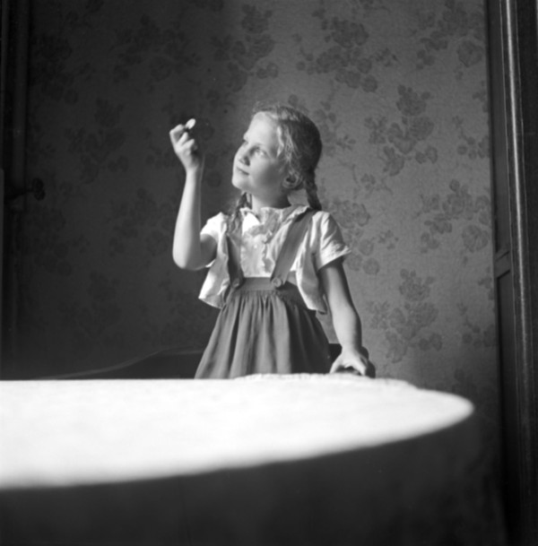 Schwarz-weiß Foto eines Mädchens, das eine Münze in der Hand hält