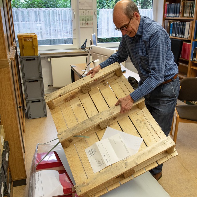 Robert Damme packt die Palette mit den ersten Exemplaren des fünften Bandes des Westfälischen Wörterbuchs aus. (öffnet vergrößerte Bildansicht)