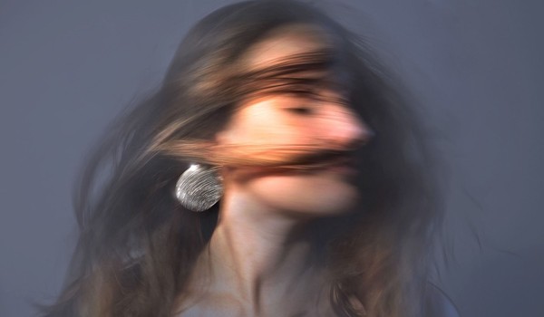 Frau, die den Kopf schüttelt, wodurch ihre Haare fliegen