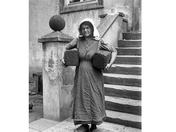Frau mit zwei Laiben Brot unterm Arm
