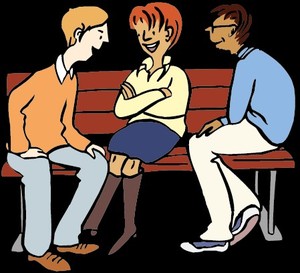 Zwei Männer und einer Frau sitzen auf einer Bank und unterhalten sich